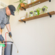 Amco Ranger service technician applying professional indoor pest control treatment along a home's baseboards, illustrating customized pest management near me for St. Louis and St. Charles homeowners.