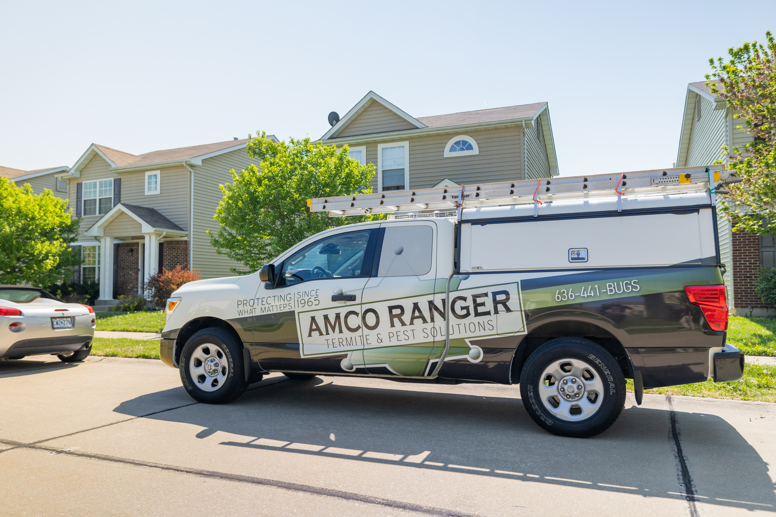 An Amco Ranger Termite & Pest Solutions service truck parked in a residential St. Louis neighborhood, providing local pest management near me for Missouri homeowners.