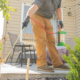 Amco Ranger exterminator applying a professional barrier treatment around a St. Louis patio to prevent pest infestations and reduce long-term pest control costs.